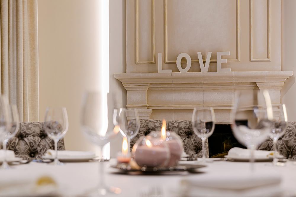Зала ресторану Villa Vita: сервірований стіл, свічки і напис LOVE